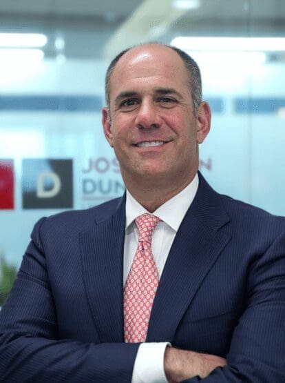 A man in suit and tie smiling for the camera.