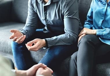 A group of people sitting on top of a couch. Speaking with nationwide unpaid wage attorneys.