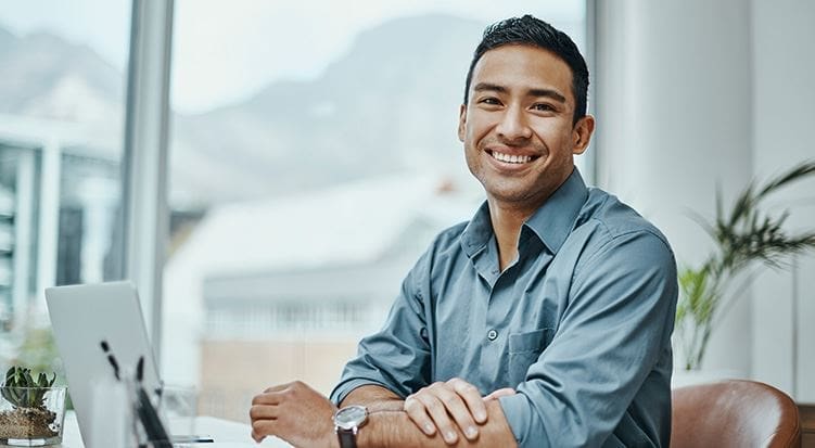 A man sitting at a table smiling for the camera.