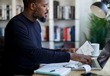 A man sitting at his desk looking at papers.