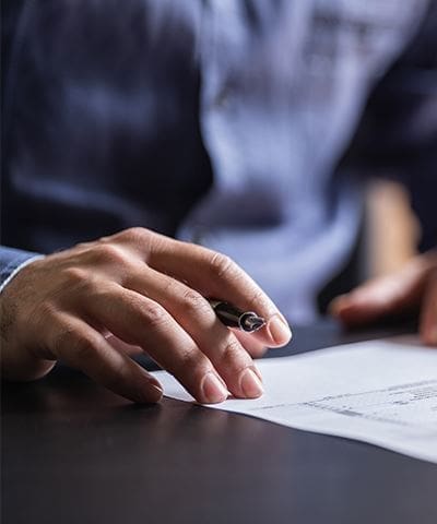 A person is writing on paper with a pen.