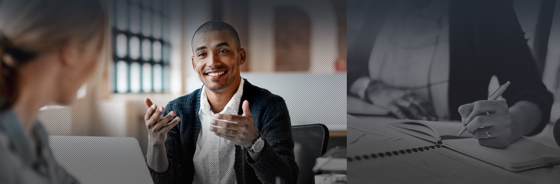 A man sitting at his desk giving the thumbs up.