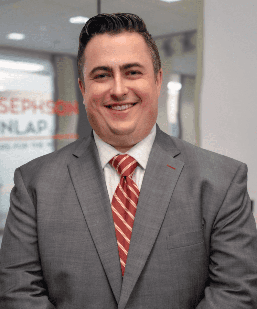 Smiling man in gray suit and tie.