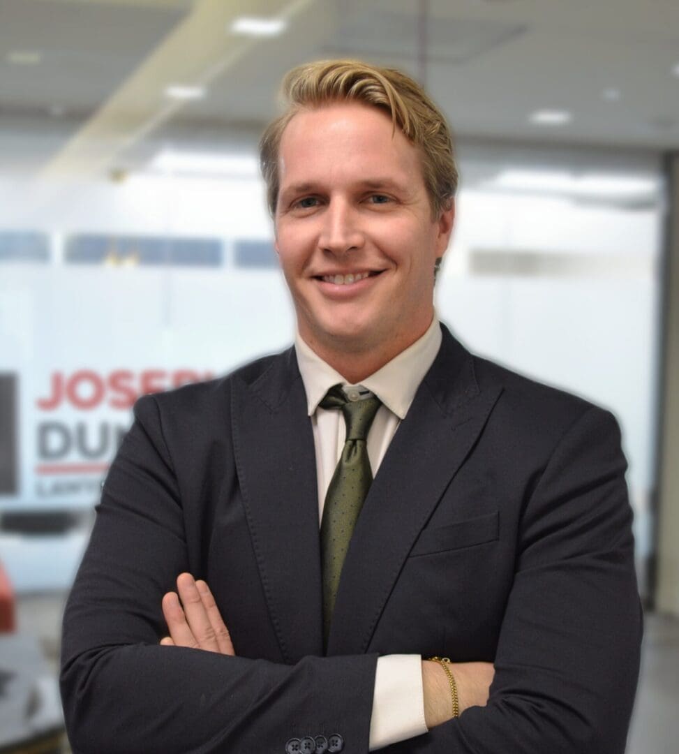 Man in suit smiling in office setting.