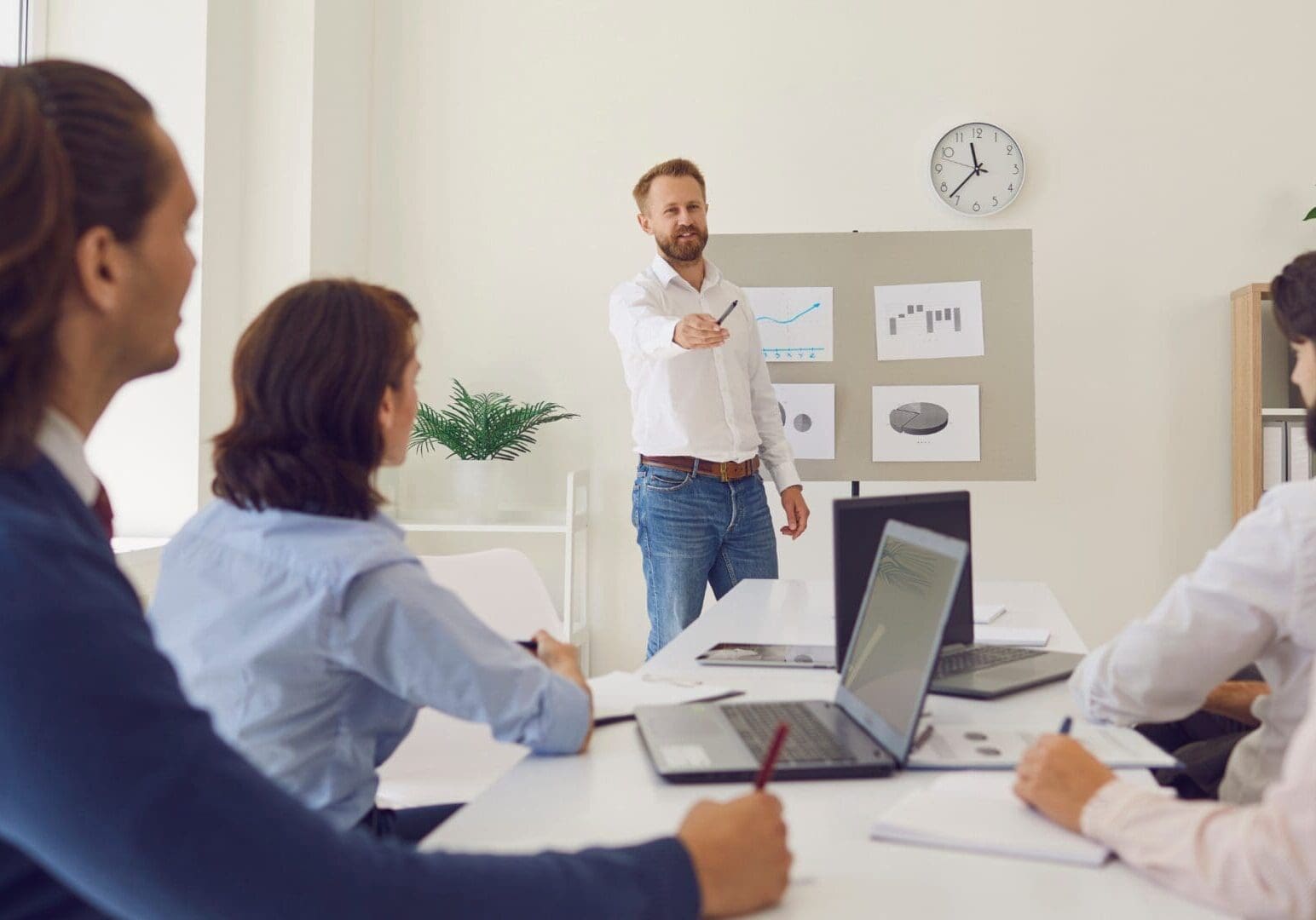 Man presenting charts to colleagues in meeting