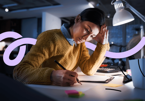 Woman working late at desk with lamp.